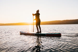 CoQ10 blog | Woman paddleboarding in the morning