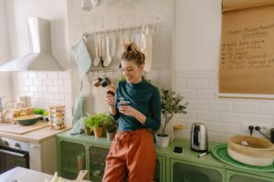 Types of diets: young woman stood in her kitchen eating