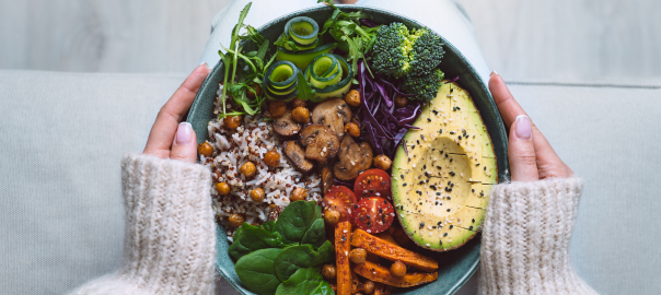 Women's hands holding a bowl of coloutful healthy food. Eating a blanced diet rich in fruit, vegetables, wholegrains, fish and healthy fats is associated with a reduced risk of Parkinson's Disease and slower disease progression.
