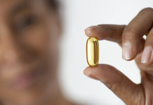 Young african woman holding up a nutritional supplement