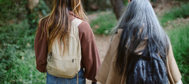 Rear view of mother and daugher hiking in a forest