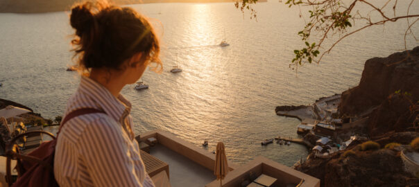 Women travelling looking out over a beautiful sunset across the sea. Can Pycnogenol (pine bark extract) prevent DVT when travelling.